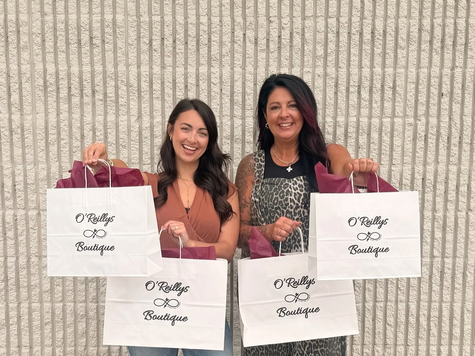 Two women holding O’Reillys Boutique shopping bags